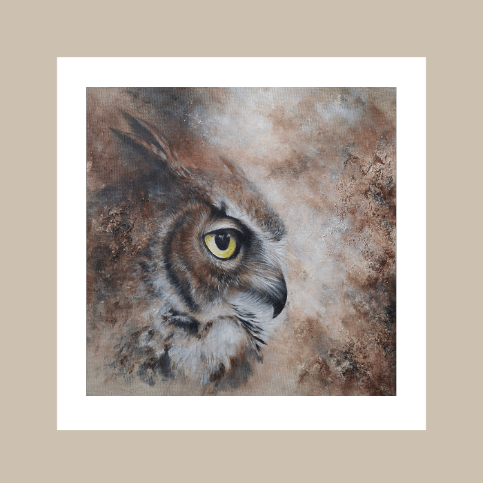 A square art print featuring a close-up painted owl with a bright yellow eye, surrounded by a wide white border and set against a beige background.